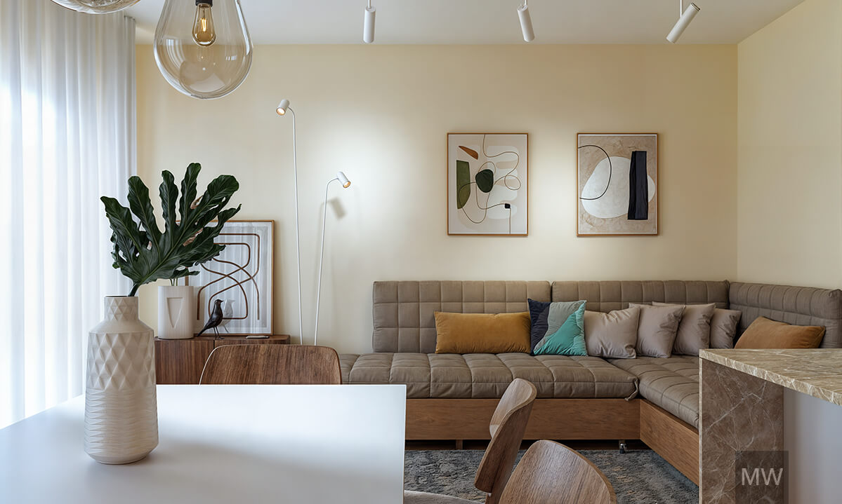 Living room with storage under the sofa and pillows Modern living room with a gray sectional sofa, abstract artworks, a wooden dining table, and natural light streaming through a large window in a family apartment